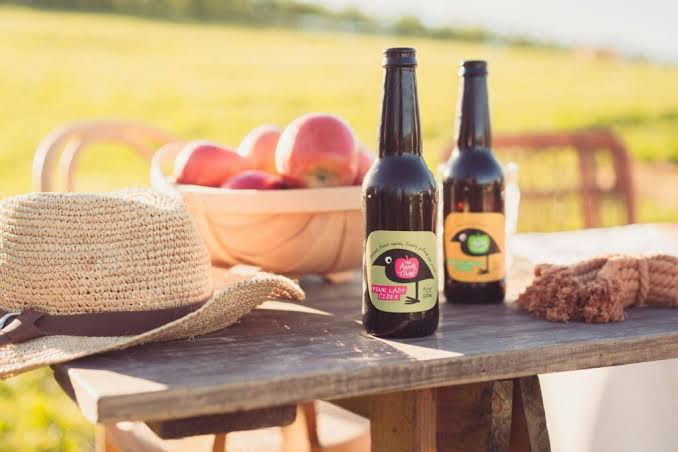 Local cider and apples on a rustic table in the Tumut countryside.